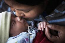 A mother kisses her infant in Chiangmai Province, Thailand. © 2010 Hansa Tangmanpoowadol, Courtesy of Photoshare